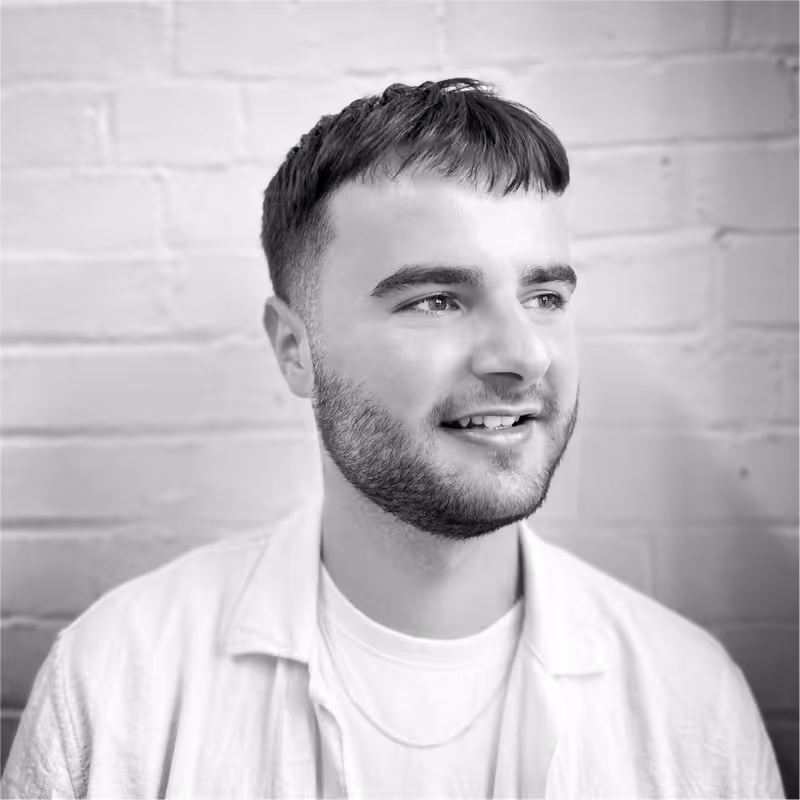 A black and white photo of a man smiling.